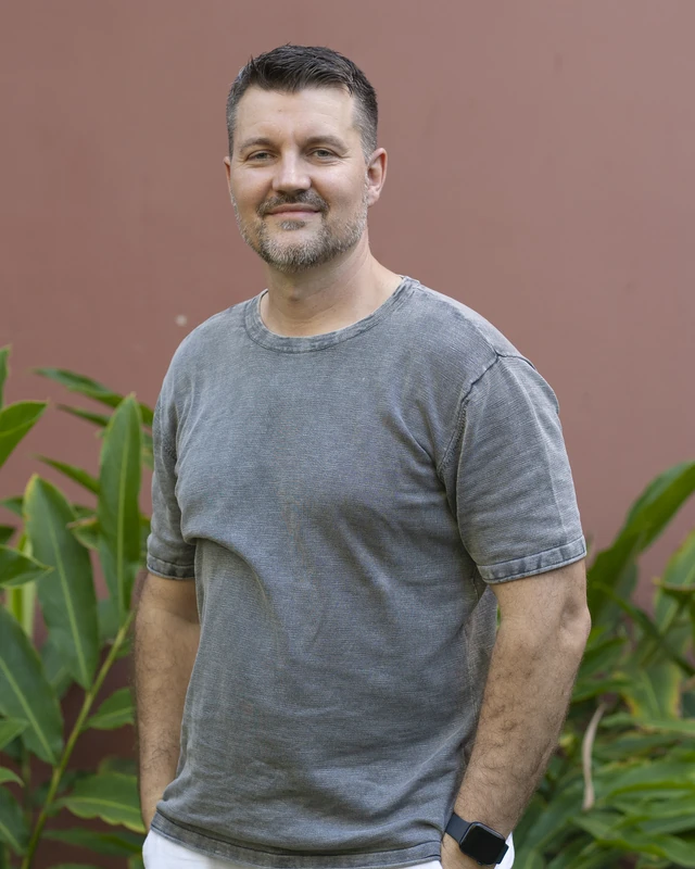 Tomislav Borić standing in front of a terracotta wall, smiling.